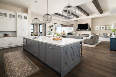 Huge transitional u-shaped dark wood floor and brown floor open concept kitchen photo in Phoenix with an undermount sink, recessed-panel cabinets, white cabinets, quartzite countertops, white backsplash, ceramic backsplash, paneled appliances, an island and white countertops