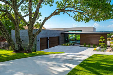 Example of a large minimalist two-story exterior home design in Austin with a mixed material roof