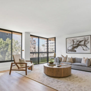 Staged Living Room With Floor-to-Ceiling Windows and Marble Fireplace