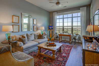 Example of a mid-sized transitional open concept medium tone wood floor and orange floor living room design in Austin with blue walls and a wall-mounted tv