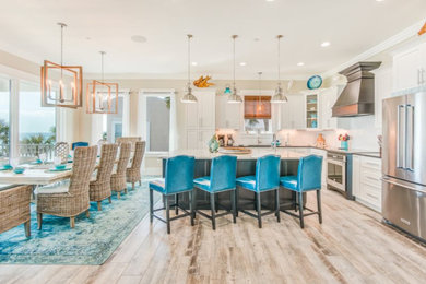 Inspiration for a mid-sized coastal l-shaped eat-in kitchen remodel in Other with an undermount sink, shaker cabinets, white cabinets, granite countertops, white backsplash, subway tile backsplash, stainless steel appliances and an island