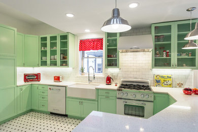 Mid-sized elegant l-shaped porcelain tile open concept kitchen photo in Chicago with a farmhouse sink, shaker cabinets, green cabinets, quartz countertops, white backsplash, subway tile backsplash, white appliances and a peninsula