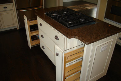 Example of a large minimalist u-shaped dark wood floor enclosed kitchen design in Raleigh with raised-panel cabinets, white cabinets, granite countertops, brown backsplash, stone slab backsplash, stainless steel appliances and an island