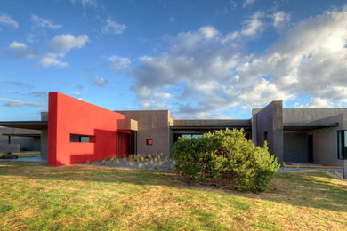 Large trendy gray one-story stucco exterior home photo in Albuquerque