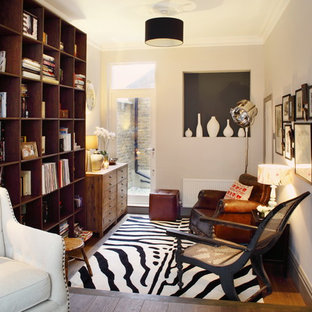 Inspiration for a small eclectic enclosed living room in London with a reading nook, white walls, medium hardwood flooring and brown floors.