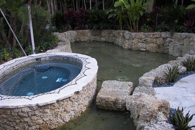 Pool fountain - transitional backyard stone and custom-shaped aboveground pool fountain idea in Miami