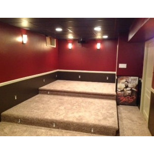 This is an example of a small enclosed home cinema in Newark with red walls, carpet, a built-in media unit and beige floors.