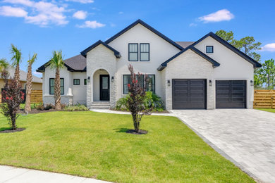 Mid-sized trendy white two-story stucco exterior home photo in Other with a shingle roof and a black roof
