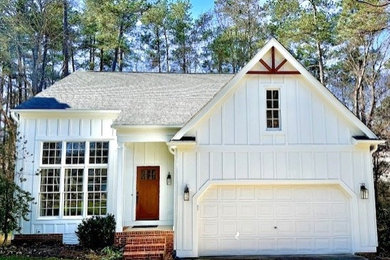 Example of a minimalist white concrete fiberboard and board and batten house exterior design in Raleigh