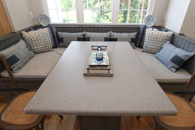 Mid-sized transitional light wood floor kitchen/dining room combo photo in Grand Rapids with beige walls, a standard fireplace and a wood fireplace surround