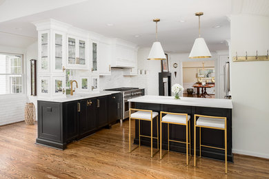 Kitchen - transitional medium tone wood floor and brown floor kitchen idea in Louisville with white cabinets, marble countertops, white backsplash, marble backsplash, stainless steel appliances, a peninsula and white countertops