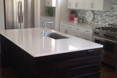 Mid-sized trendy galley dark wood floor eat-in kitchen photo in Raleigh with an undermount sink, flat-panel cabinets, black cabinets, quartz countertops, gray backsplash, stainless steel appliances and an island
