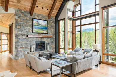 Inspiration for a rustic open concept light wood floor, beige floor and vaulted ceiling living room remodel in Other with white walls and a standard fireplace