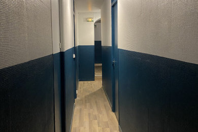 Aménagement d'un couloir bord de mer de taille moyenne avec un mur bleu, parquet clair et du papier peint.