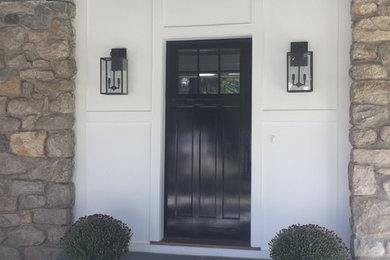 Inspiration for a mid-sized transitional medium tone wood floor and gray floor entryway remodel in New York with white walls and a black front door