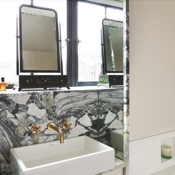 Bathroom: Mirrors flanking the marble framed vanity cabinet