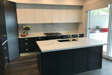 Inspiration for a large contemporary galley eat-in kitchen in Sydney with an undermount sink, shaker cabinets, black cabinets, quartz benchtops, white splashback, stone slab splashback, black appliances, with island and white benchtop.