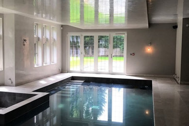Inspiration for a contemporary indoor swimming pool in Manchester with a pool house.