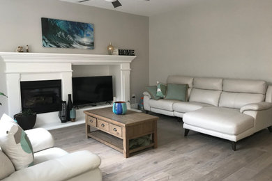 Living room - mid-sized modern formal and open concept medium tone wood floor, multicolored floor, vaulted ceiling and shiplap wall living room idea in Other with beige walls, a standard fireplace, a metal fireplace and a tv stand