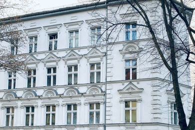 Großes Klassisches Haus mit Mix-Fassade, weißer Fassadenfarbe, Flachdach, Ziegeldach und grauem Dach in Berlin