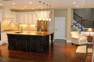 Example of a classic u-shaped eat-in kitchen design in Dallas with stainless steel cabinets, granite countertops, white backsplash, stone tile backsplash and stainless steel appliances