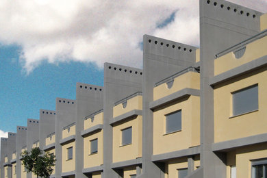 Ejemplo de fachada multicolor minimalista grande de tres plantas con revestimiento de estuco y tejado plano