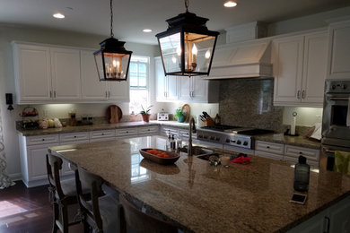 Eat-in kitchen - large u-shaped porcelain tile and brown floor eat-in kitchen idea in San Diego with a double-bowl sink, raised-panel cabinets, white cabinets, granite countertops, multicolored backsplash, granite backsplash, stainless steel appliances, an island and multicolored countertops