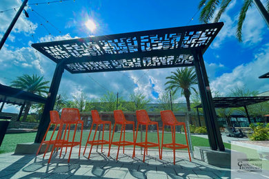 This is an example of a large urban courtyard patio in Other with a pergola.