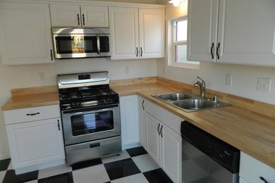 Small elegant l-shaped ceramic tile and multicolored floor eat-in kitchen photo in Los Angeles with a double-bowl sink, shaker cabinets, white cabinets, wood countertops, stainless steel appliances, white backsplash, no island and brown countertops