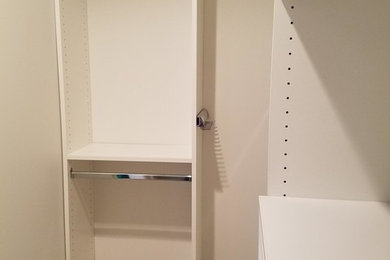 Example of a small classic gender-neutral carpeted and brown floor walk-in closet design in Louisville with open cabinets and white cabinets
