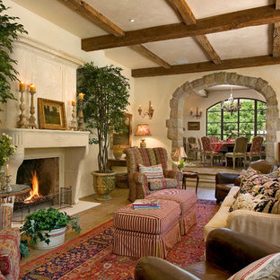Geräumiges, Abgetrenntes Mediterranes Wohnzimmer mit gelber Wandfarbe, braunem Holzboden und Kamin in Santa Barbara