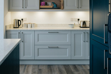Design ideas for a large modern l-shaped kitchen/diner in Other with shaker cabinets, blue cabinets, granite worktops, grey splashback, granite splashback, integrated appliances, an island and grey worktops.