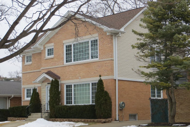 Inspiration for a mid-sized timeless orange two-story brick exterior home remodel in Chicago with a shingle roof