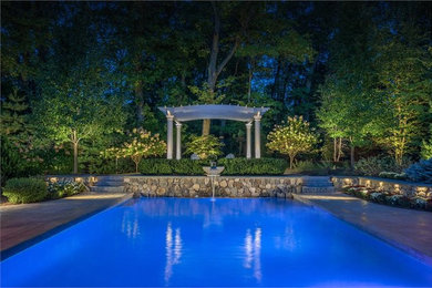 Inspiration for a mid-sized timeless backyard stamped concrete and rectangular natural pool fountain remodel in Boston