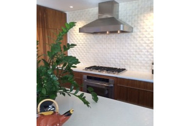 Example of a trendy u-shaped open concept kitchen design in Phoenix with flat-panel cabinets, medium tone wood cabinets, quartz countertops, beige backsplash, ceramic backsplash and an island