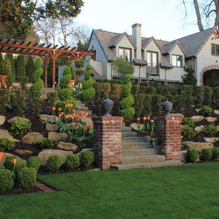 Traditional sloped garden in Seattle with with rock feature for spring.