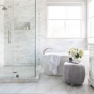 Exemple d'une salle de bain principale chic de taille moyenne avec un placard à porte shaker, des portes de placard blanches, une baignoire indépendante, un carrelage blanc, du carrelage en marbre, un mur gris, un sol en marbre, un lavabo encastré, un plan de toilette en marbre, un sol blanc, une cabine de douche à porte battante et un plan de toilette blanc.