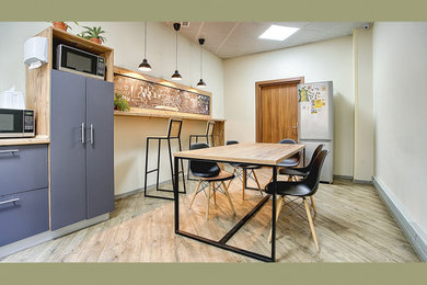 На фото: прямая кухня среднего размера с обеденным столом, островом и бежевой столешницей с