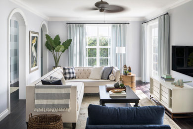 Example of a large beach style formal and open concept dark wood floor and brown floor living room design in Miami with gray walls and a wall-mounted tv