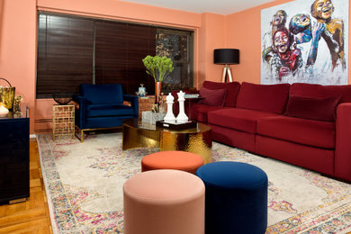 Ejemplo de salón abierto contemporáneo grande con parades naranjas, suelo de madera clara y televisor colgado en la pared