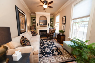 Inspiration for a small craftsman enclosed light wood floor and brown floor family room remodel in Other with beige walls, a standard fireplace, a wood fireplace surround and a tv stand