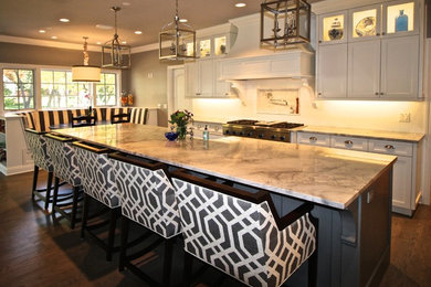 Large transitional single-wall medium tone wood floor and brown floor eat-in kitchen photo in Omaha with a farmhouse sink, flat-panel cabinets, white cabinets, granite countertops, white backsplash, ceramic backsplash, stainless steel appliances and an island