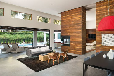 Example of a large trendy open concept concrete floor living room design in Austin with white walls, a two-sided fireplace, a wood fireplace surround and a wall-mounted tv