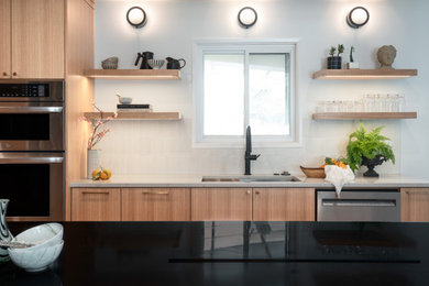 Mid-sized danish u-shaped light wood floor and brown floor eat-in kitchen photo in Portland with an undermount sink, flat-panel cabinets, light wood cabinets, quartzite countertops, white backsplash, cement tile backsplash, stainless steel appliances and multicolored countertops