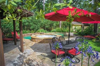 Inspiration for a large traditional backyard patio in Houston with natural stone pavers and a gazebo/cabana.