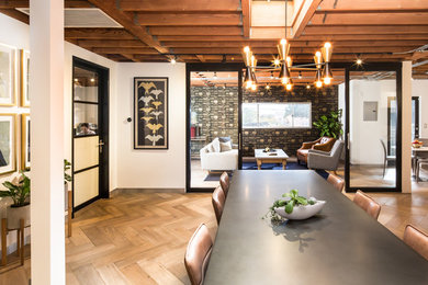 Large transitional freestanding desk light wood floor and brown floor study room photo in Los Angeles with beige walls
