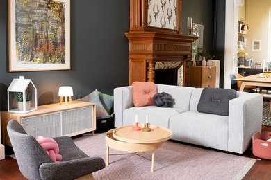 Réalisation d'un grand salon design ouvert avec une salle de réception, un mur bleu, parquet foncé, une cheminée standard, un manteau de cheminée en bois et un sol marron.
