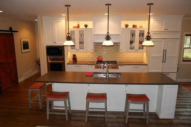 Large transitional single-wall dark wood floor open concept kitchen photo in Other with an undermount sink, shaker cabinets, white cabinets, granite countertops, beige backsplash, ceramic backsplash, paneled appliances and an island