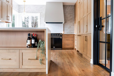 Eat-in kitchen - mid-sized transitional medium tone wood floor eat-in kitchen idea in Minneapolis with an undermount sink, shaker cabinets, medium tone wood cabinets, quartz countertops, gray backsplash, porcelain backsplash, paneled appliances, a peninsula and white countertops