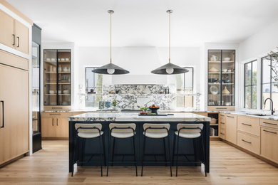 Transitional u-shaped medium tone wood floor and brown floor eat-in kitchen photo in Chicago with an undermount sink, recessed-panel cabinets, light wood cabinets, marble countertops, multicolored backsplash, marble backsplash, paneled appliances, an island and multicolored countertops